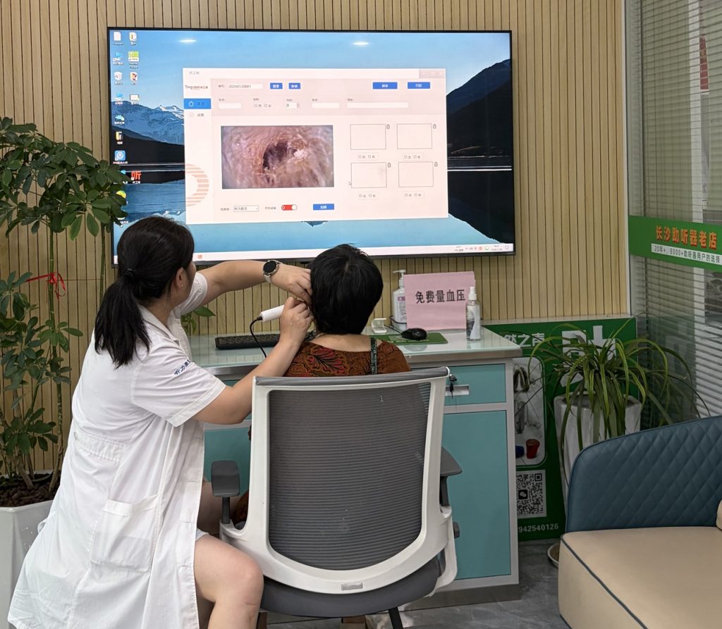 自然之声长沙袁家岭老店国家三级验配师周丽为用户做可视耳道检查